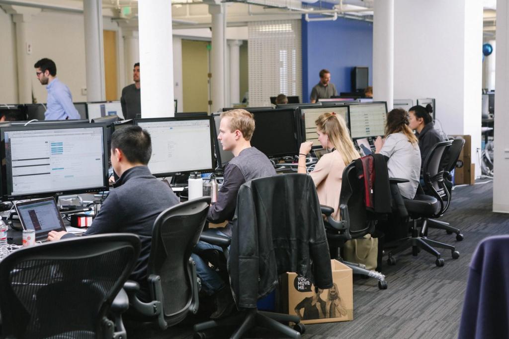 Employees working at computers in an open-plan office, with a You Move Me box beside a desk