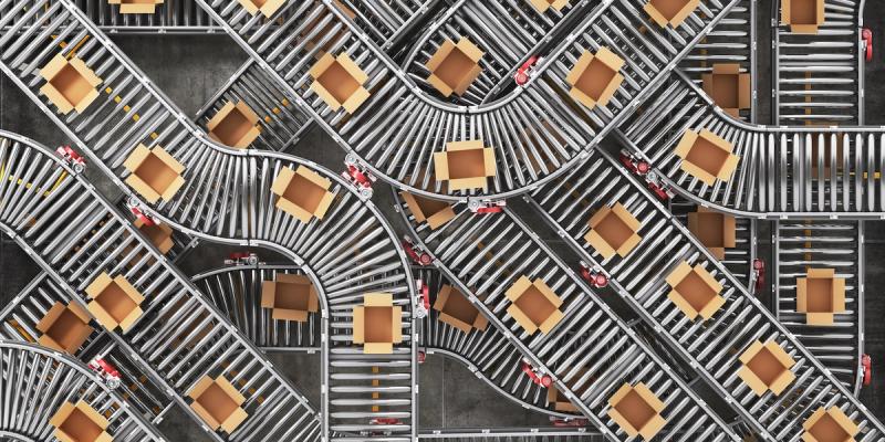 Overhead view of cardboard boxes traveling on a sprawling network of curved roller conveyors