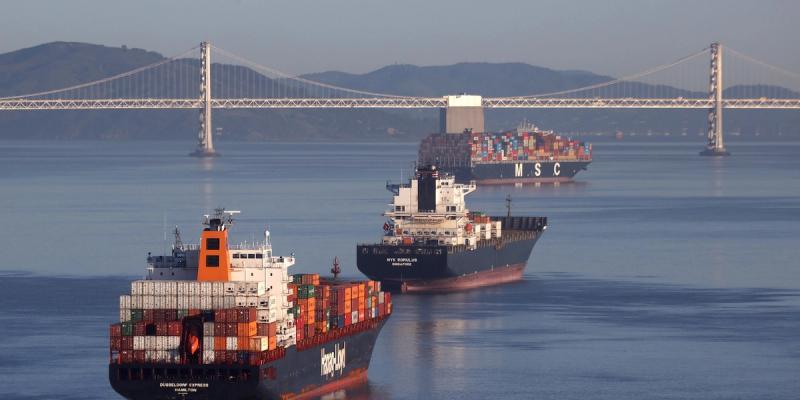Hapag-Lloyd, NYK and MSC container ships on calm water near the San Francisco-Oakland Bay Bridge