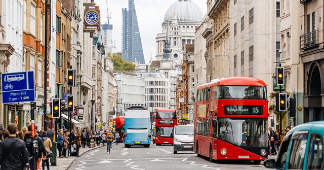 Busy London street with a red double-decker bus, traffic and pedestrians near St Paul's Cathedral dome