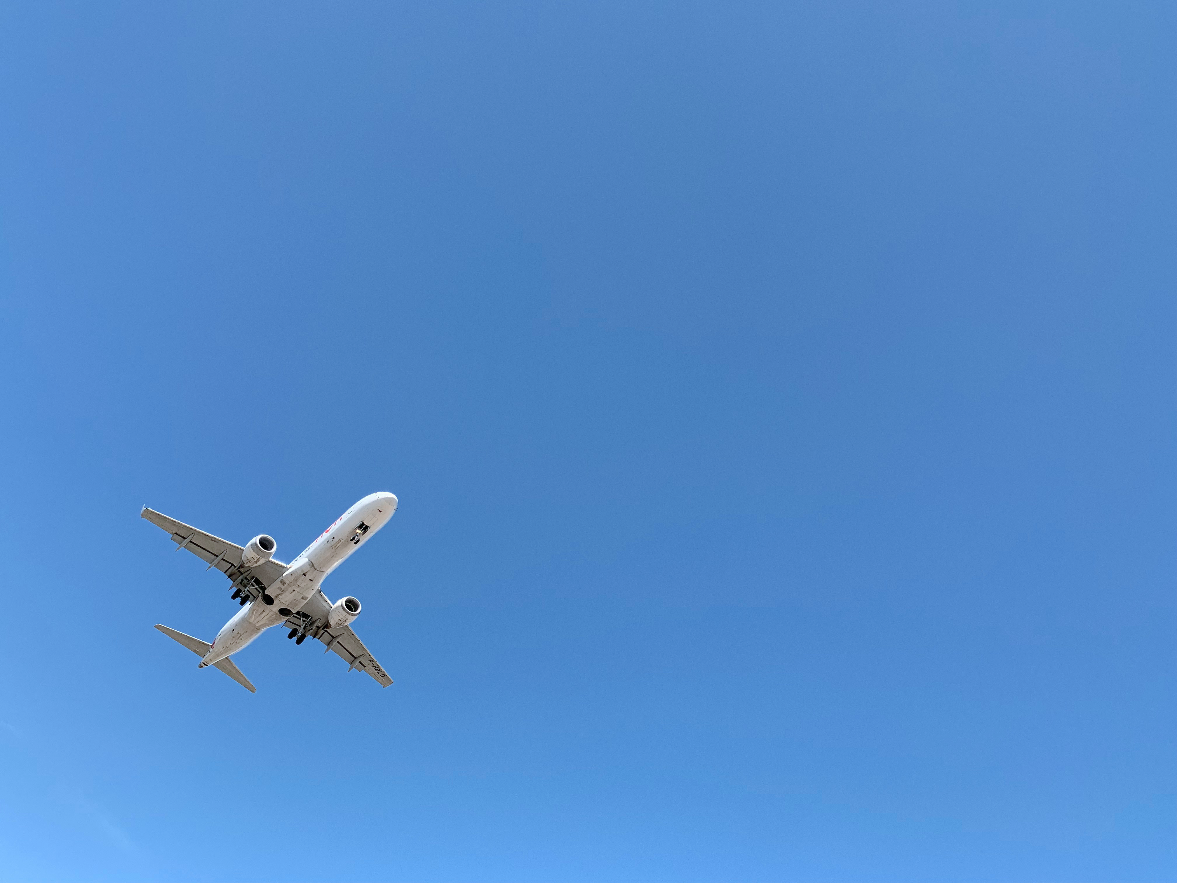Commercial airplane in flight viewed from below against clear sky.