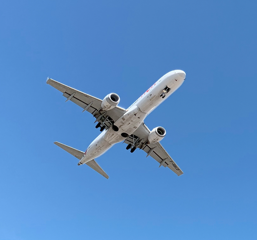 Commercial airplane in flight viewed from below against clear sky.