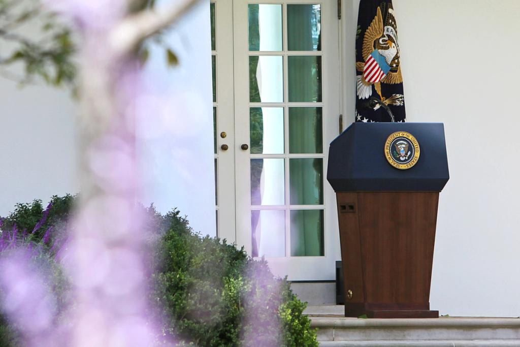 Empty presidential lectern with the seal of the President of the United States outside the White House.