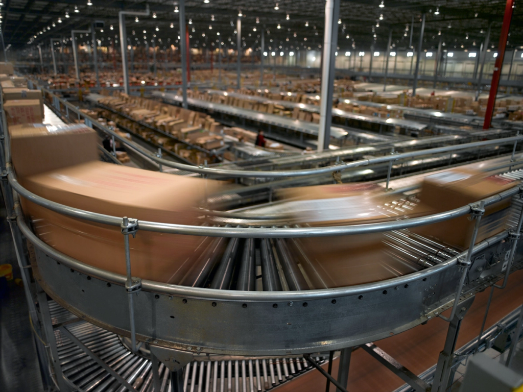 Industrial conveyor belts transport products through a large factory facility.