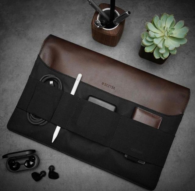 Ekster brown leather tech organizer roll with cables and accessories on a desk
