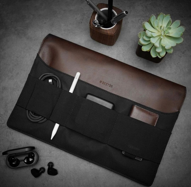 Ekster brown leather tech organizer roll with cables and accessories on a desk