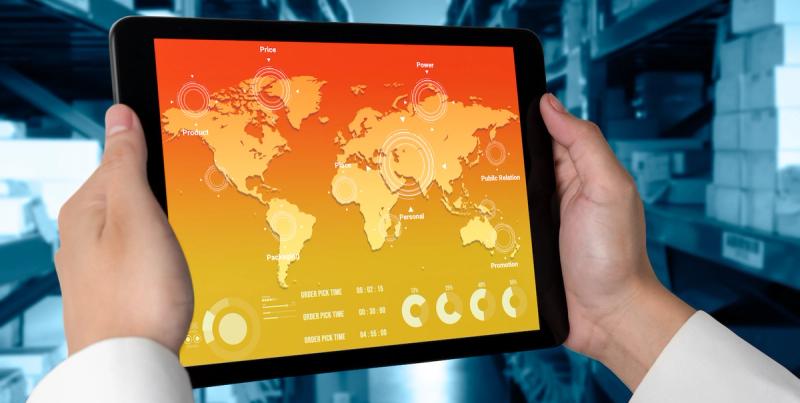 Hands hold a tablet displaying an orange world map dashboard with marketing labels and order metrics
