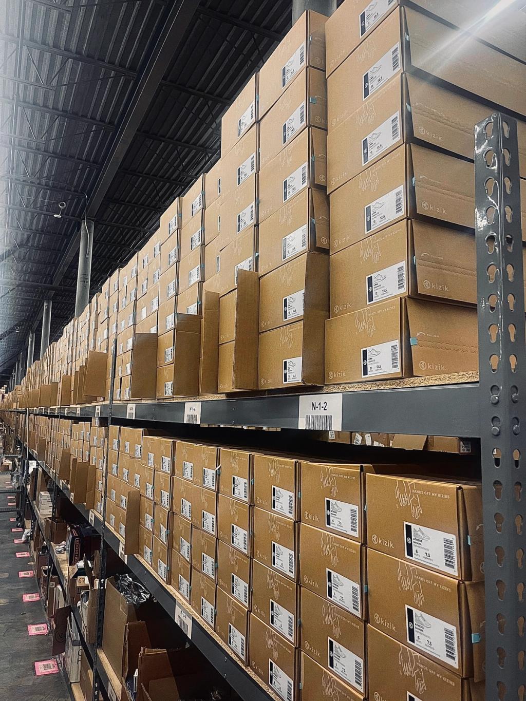 Warehouse shelving stacked with rows of labeled cardboard shipping boxes