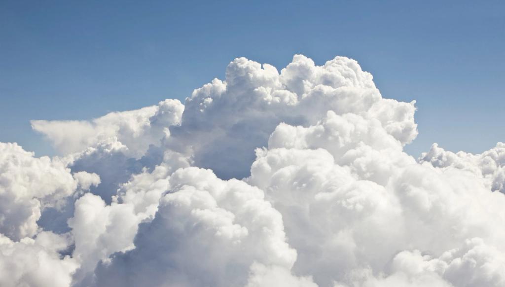Towering cumulus clouds with billowing formations against a clear sky.