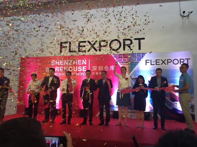 People cut a ribbon under confetti at the Flexport Shenzhen Warehouse opening ceremony.