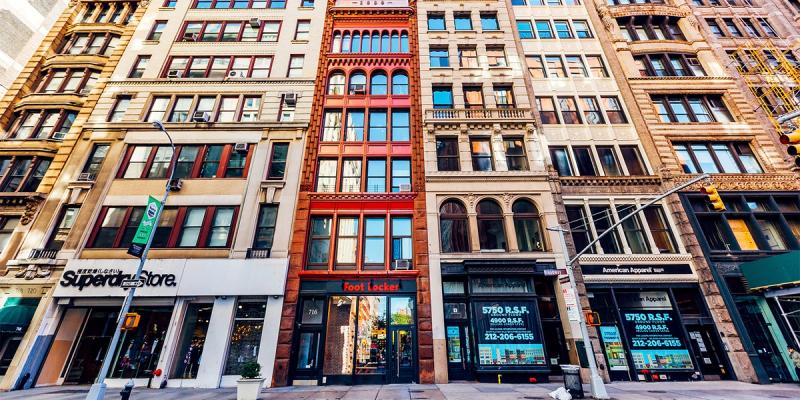 Row of colorful historic multistory storefront buildings along a city street