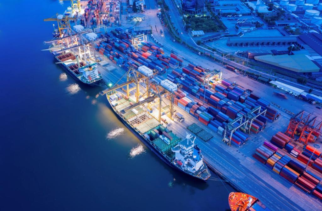 Aerial dusk view of a container terminal with two ships berthed, gantry cranes and stacked containers beside dark blue water