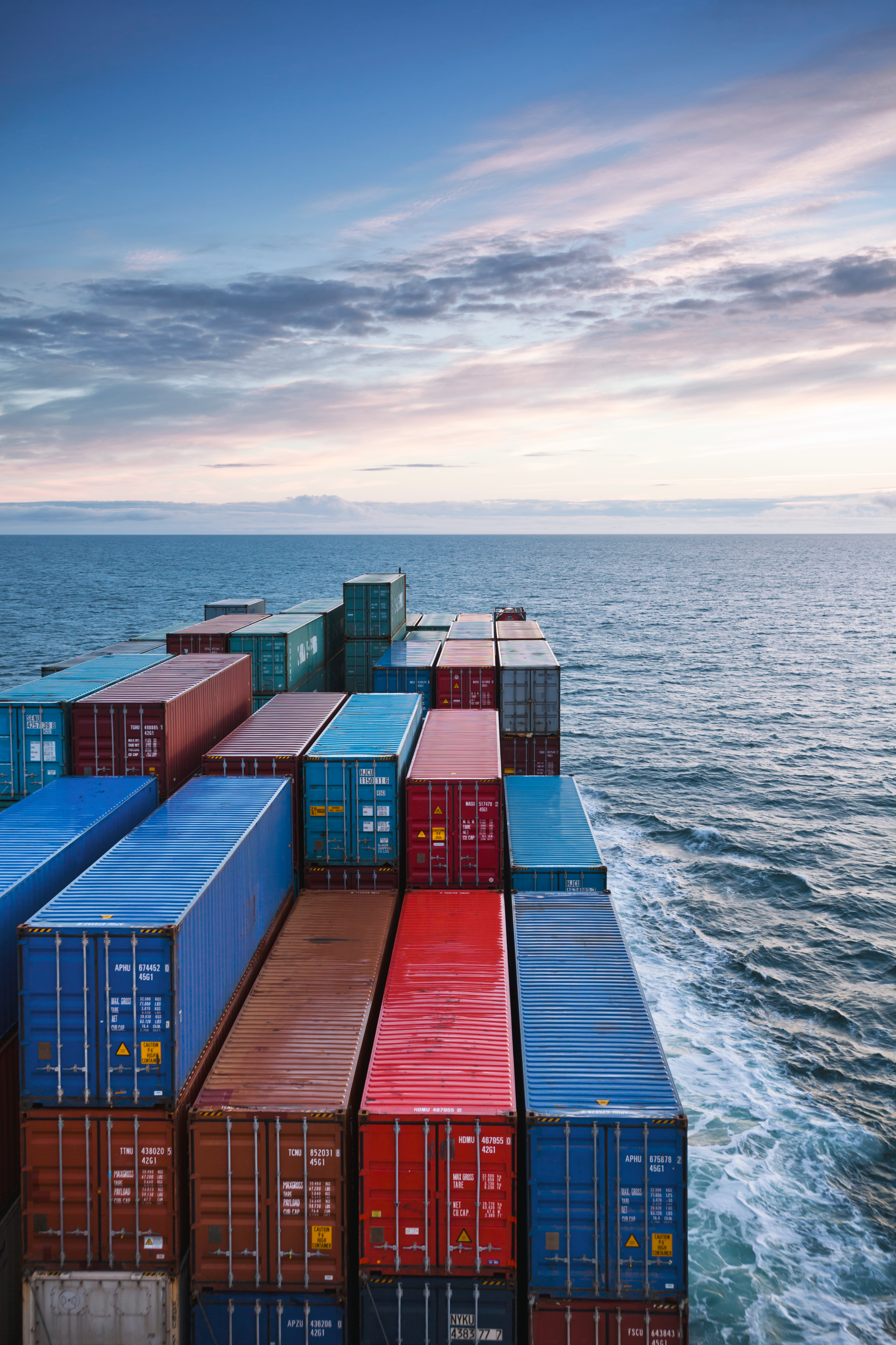 Shipping containers stacked on a cargo ship deck over ocean water.