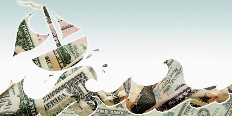 Illustration of a sailboat and waves cut from U.S. dollar bills against a pale sky