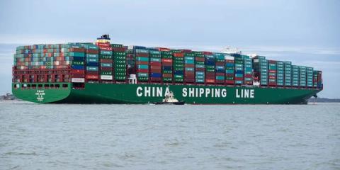 Green China Shipping Line container vessel fully loaded with containers, assisted by a tugboat