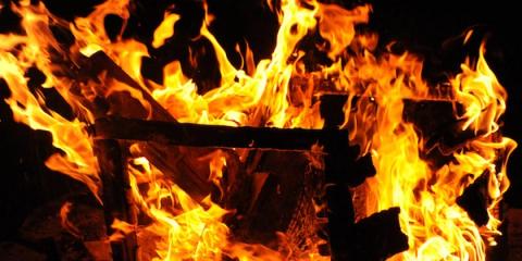 Close-up of an intense fire engulfing burning wooden logs at night