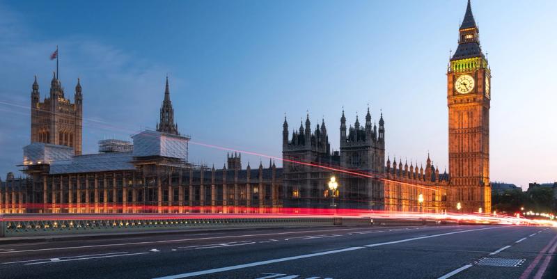 Big Ben and the Houses of Parliament at dusk with red traffic light trails across Westminster Bridge.