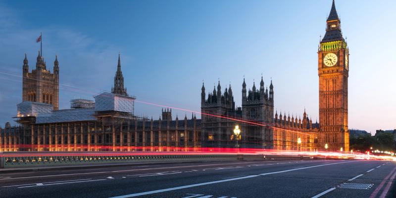Big Ben and the Houses of Parliament at dusk with red traffic light trails across Westminster Bridge.