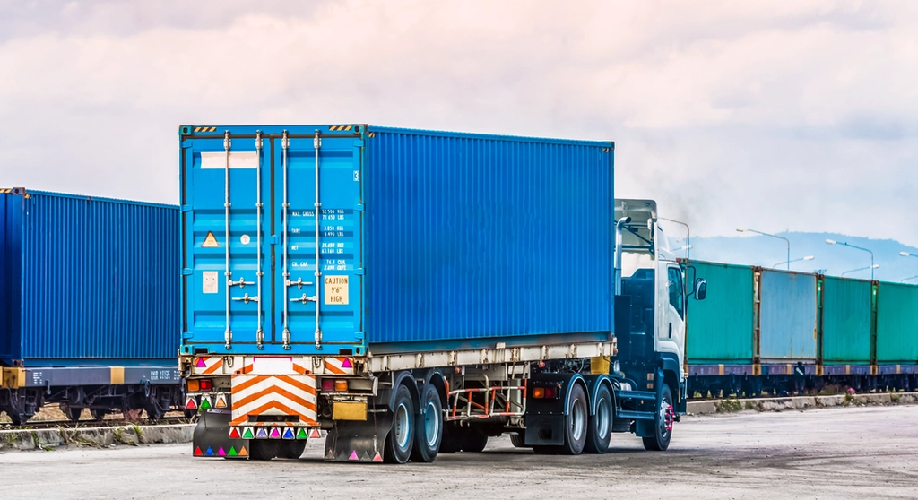 Large truck hauling a container at a port