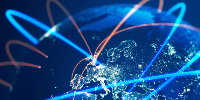 3D night-view globe centered on Europe with glowing blue and orange arcs depicting global trade routes
