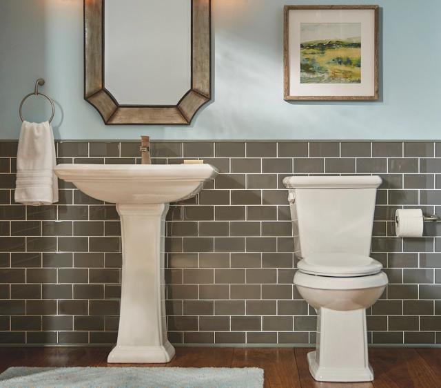 Bathroom fitted with a Gerber pedestal sink and toilet against grey subway tile