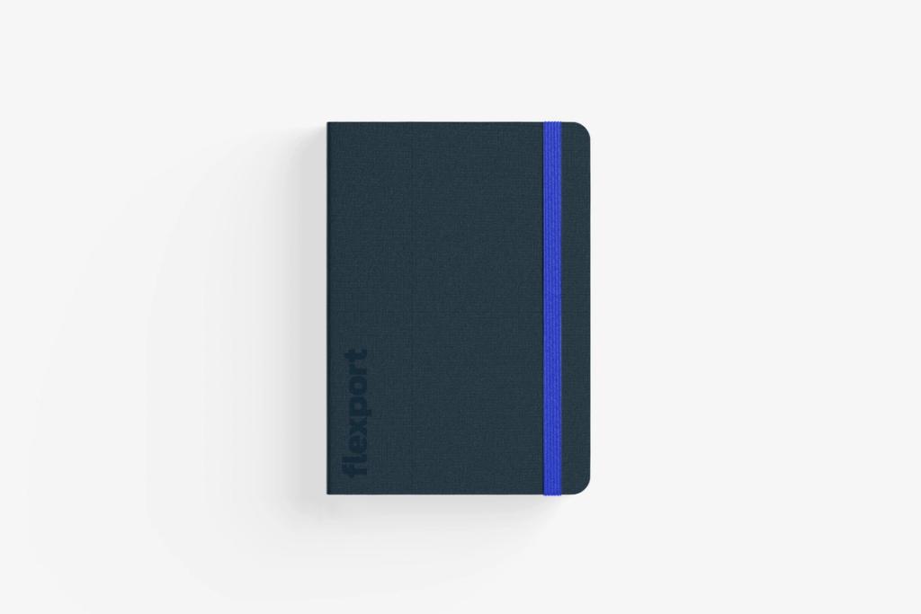 A closed notebook with elastic band closure and ribbon bookmark.