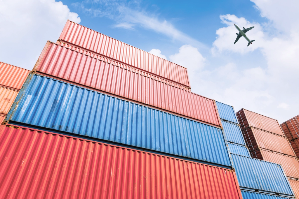 Stacked shipping containers at a cargo port represent global logistics and international trade operations.