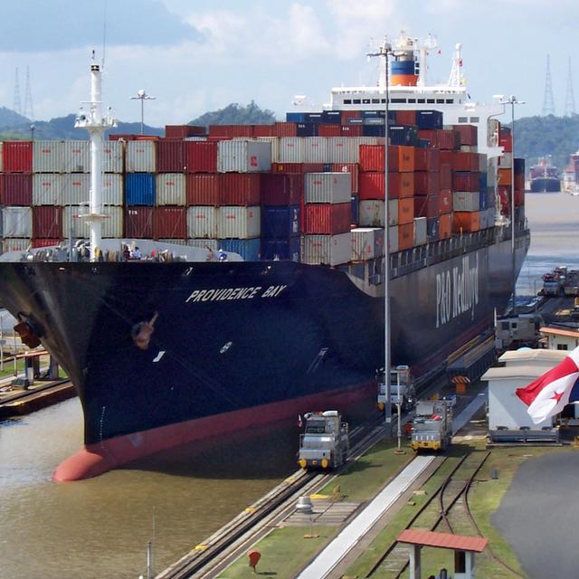 Container ship Providence Bay transiting a Panama Canal lock with towing locomotives alongside