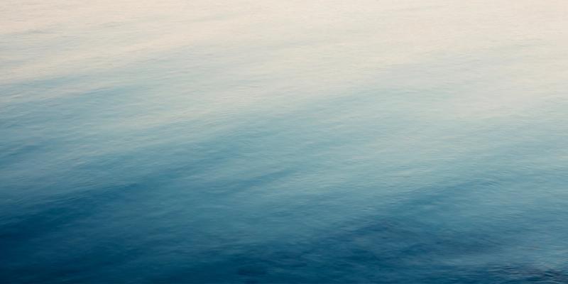 Calm blue ocean water gradient from pale to deep blue with gentle ripples