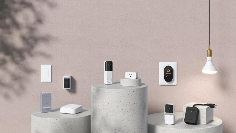 Wyze smart home devices including doorbell, thermostat, plug and switch displayed on concrete pedestals