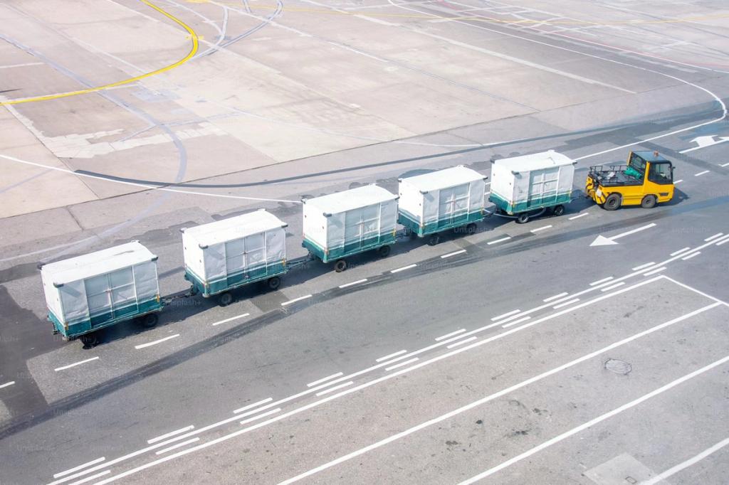 Forklift towing a train of cargo trailers on an airport runway.