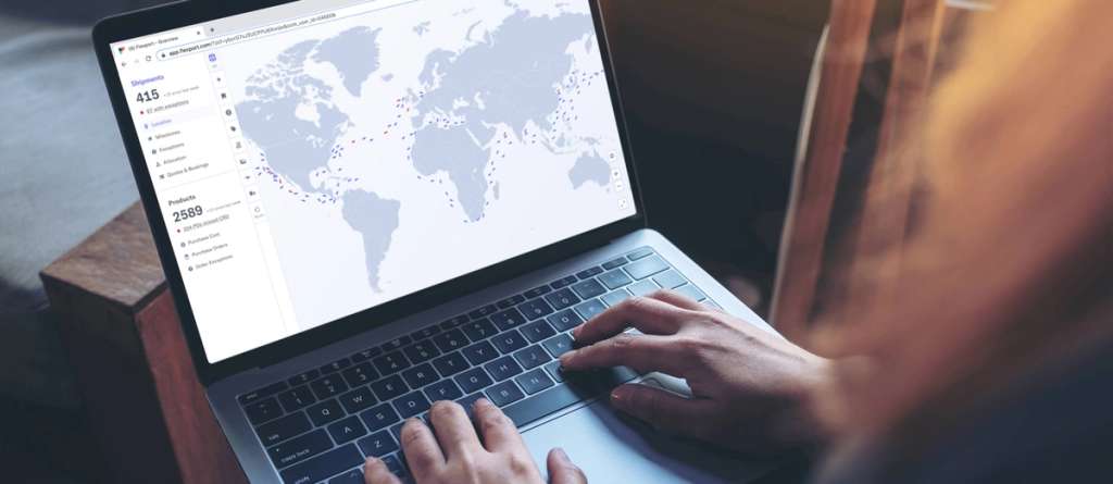 Person typing on a laptop showing the Flexport dashboard with a world shipping map and shipment counts