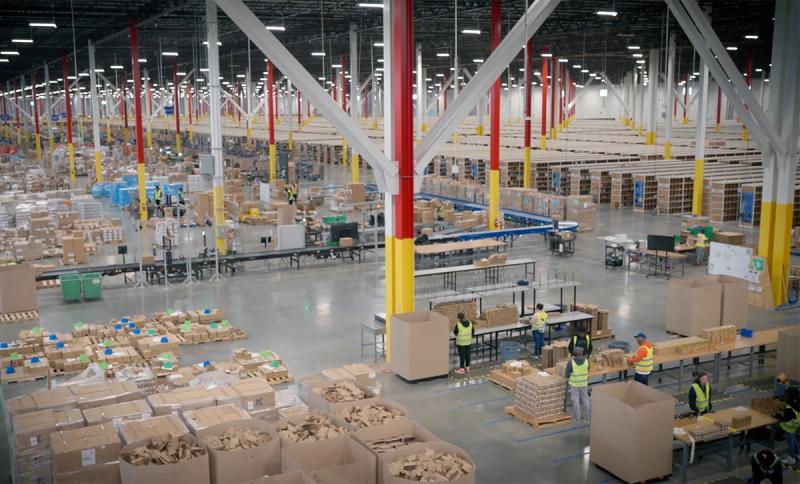 New Jersey fulfillment center floor with workers packing boxes at sortation stations