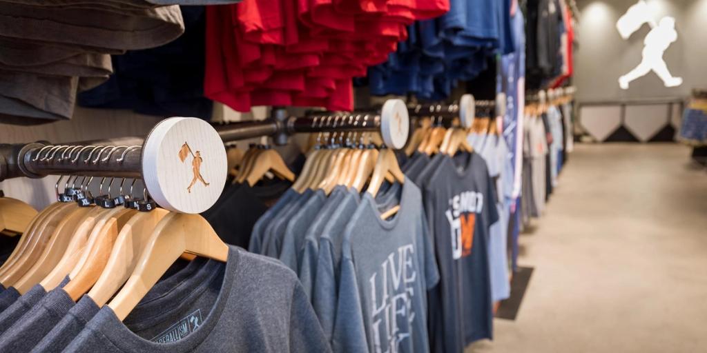 Racks of folded and hanging t-shirts in a Baseballism retail store