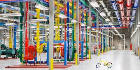 Data center interior with rows of brightly colored cooling pipes and a yellow bicycle on the floor