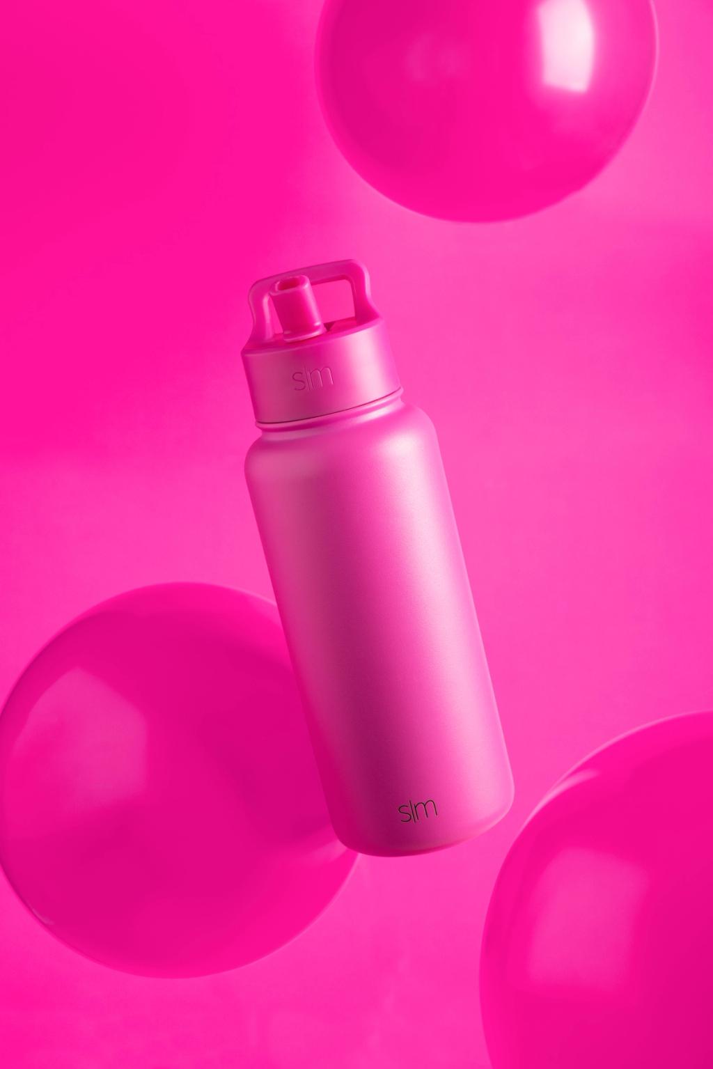 Pink Simple Modern insulated water bottle floating among glossy pink spheres on a pink backdrop