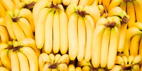 Close-up of many bunches of ripe yellow bananas stacked together