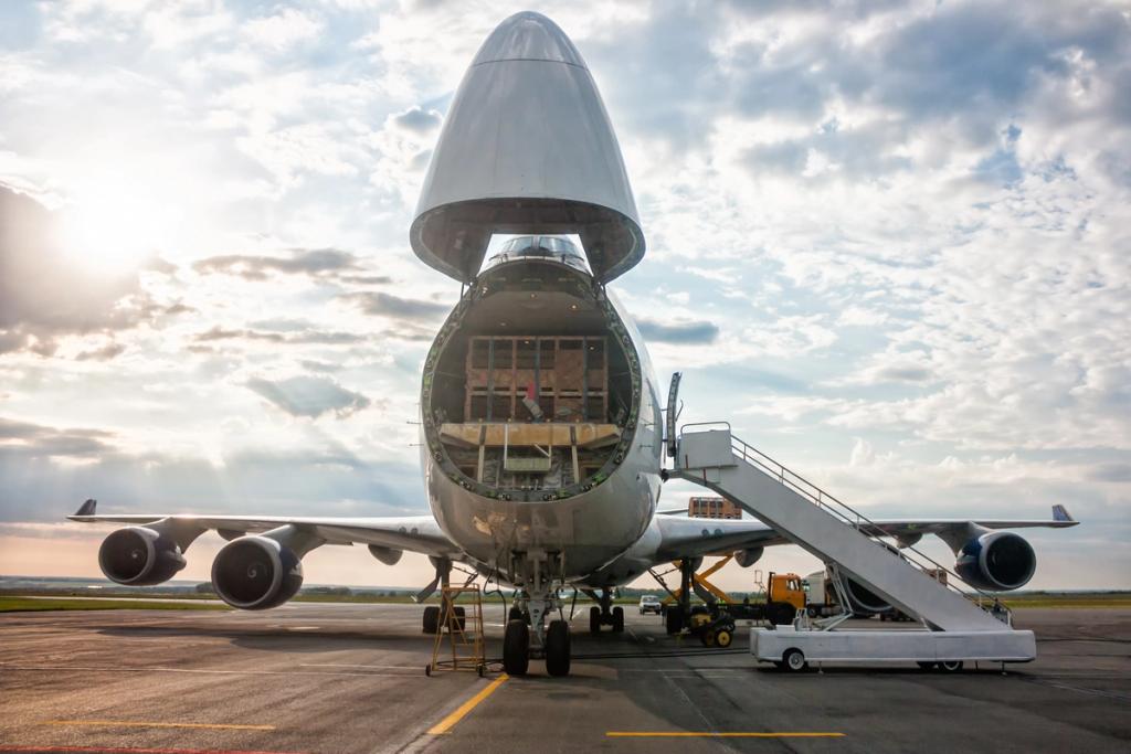 Nose-cargo-door of a Boeing 747 freighter open on the tarmac with loading stairs and ground equipment under a cloudy sky