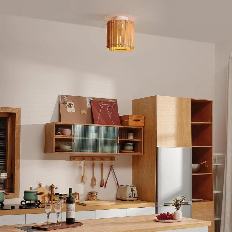 Cozy kitchen interior with wood cabinets, a woven ceiling pendant light, and wine glasses on the counter