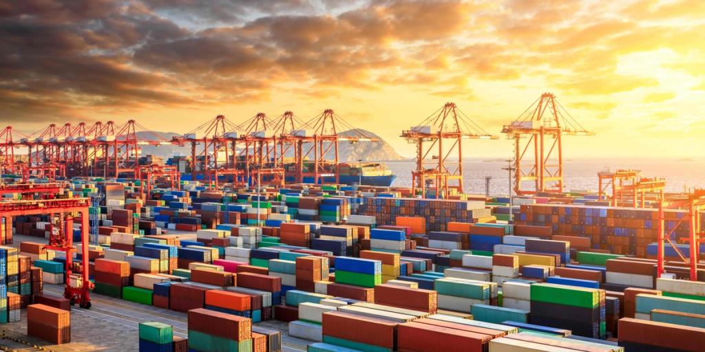 Container terminal stacked with shipping containers and gantry cranes at a port under a golden sunset