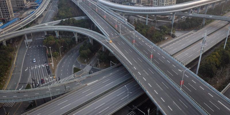 Aerial view of an empty multi-level highway interchange with almost no traffic.