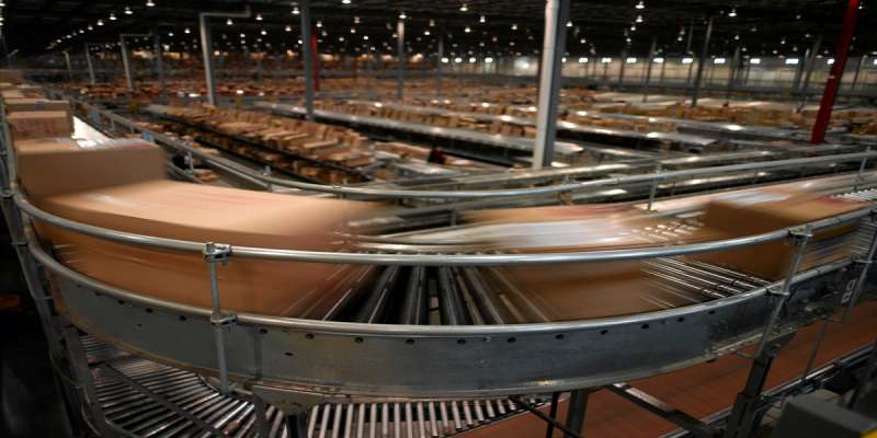 Multiple packages whirring by on a conveyor belt inside a warehouse