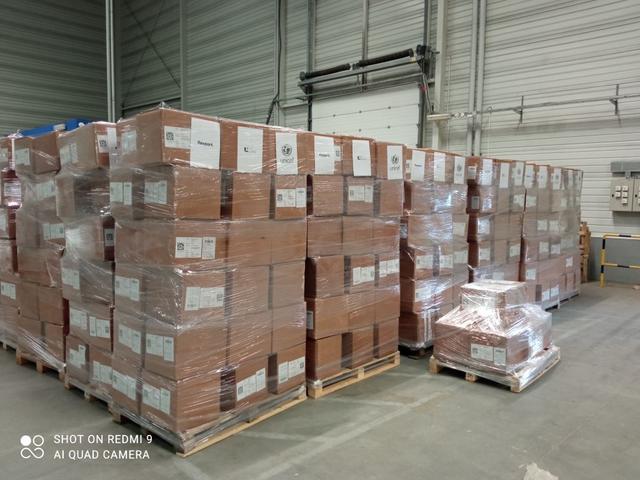 Shrink-wrapped pallets of boxes labeled Flexport and UNICEF stacked in a warehouse