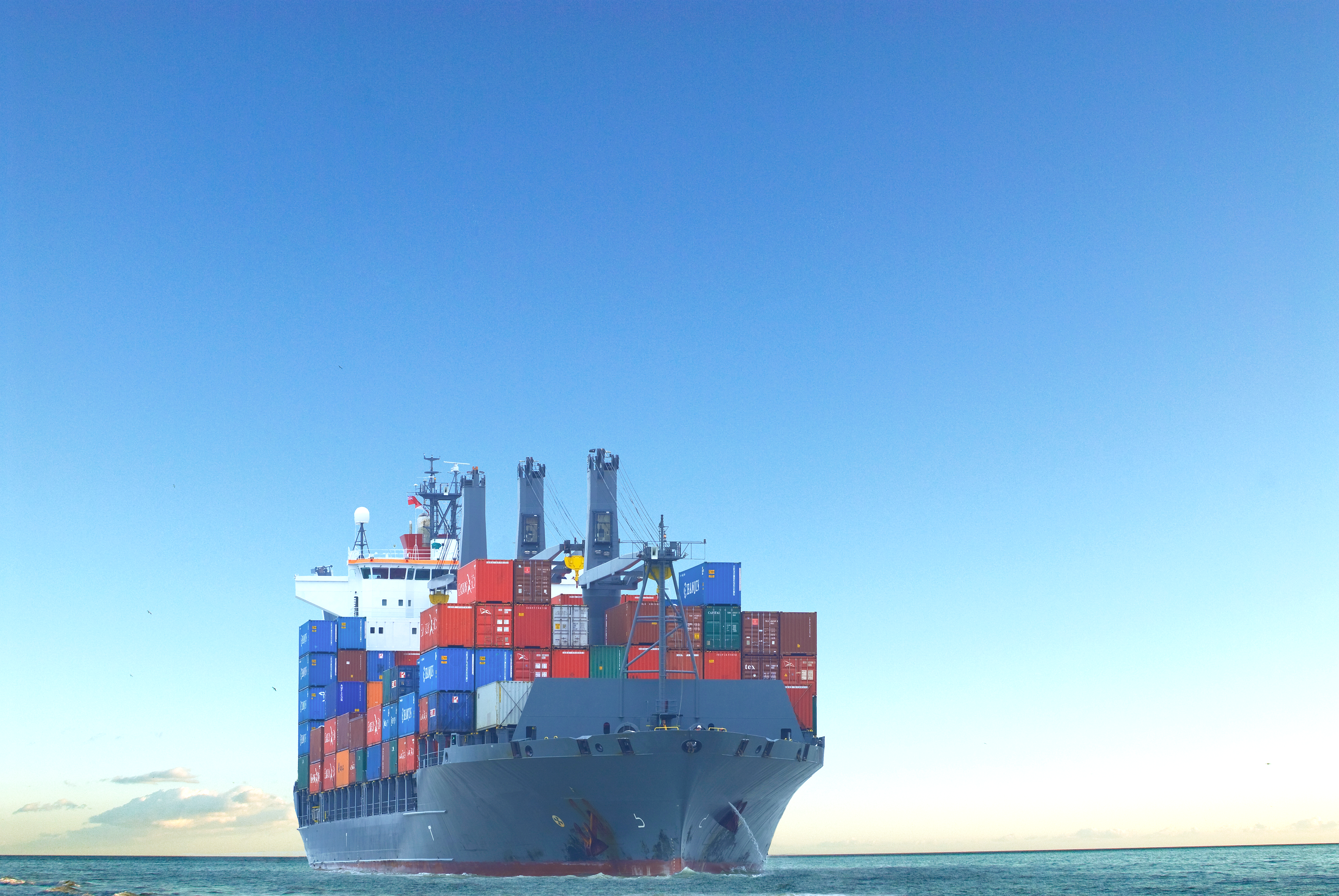 Large cargo ship transporting shipping containers across the ocean.