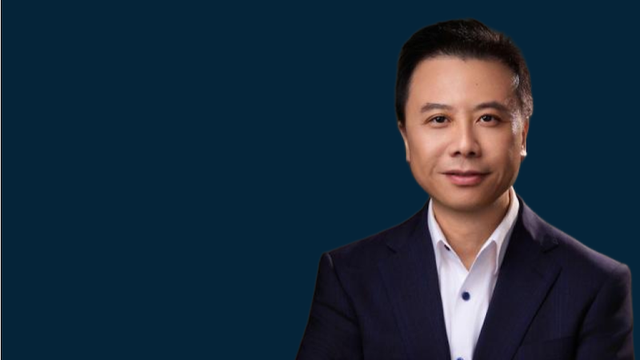 Portrait of Rick Tang, Flexport's General Manager of Greater China, in a dark navy suit against a navy background.