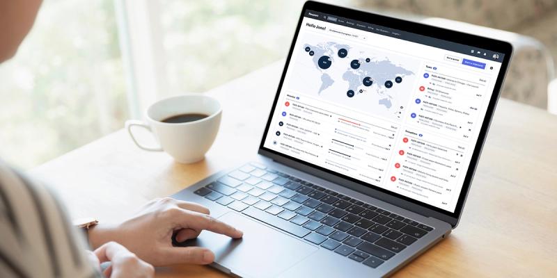 Person at a laptop showing the Flexport platform dashboard with a coffee cup nearby