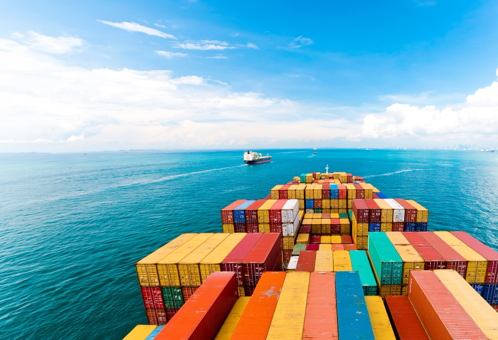 A cargo ship loaded with shipping containers in open ocean, demonstrating maritime logistics.