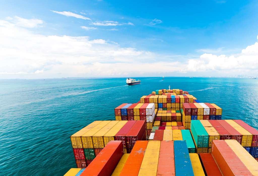 A cargo ship loaded with shipping containers in open ocean, demonstrating maritime logistics.