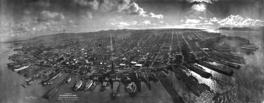 Black-and-white aerial panorama of San Francisco in ruins after the 1906 earthquake, ships lining the waterfront.