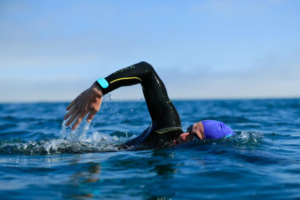 Open-water swimmer in a wetsuit and purple cap doing freestyle stroke wearing a Sharkbanz band